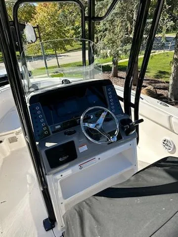 Slide: The Image of 2021 Robalo R230 Center Console boat helm with steering wheel and controls. - 5