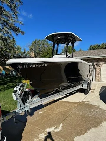 Slide: The Image of 2021 Robalo R230 Center Console boat on trailer in driveway. - 6