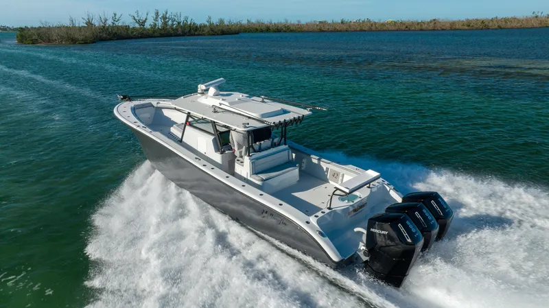 Slide: The Image of 2023 Yellowfin 42 boat cruising on open water with triple outboard engines. - 17