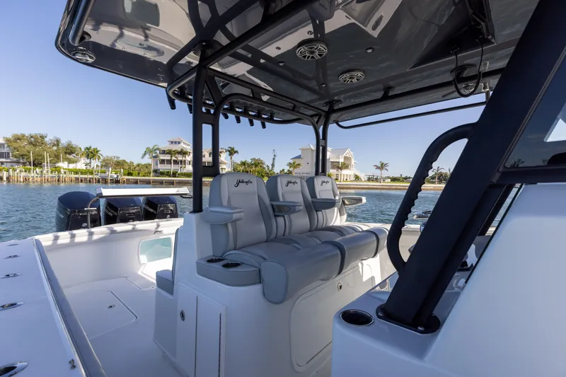 Slide: The Image of 2023 Yellowfin 42 boat interior with seating and console, docked near waterfront homes. - 38