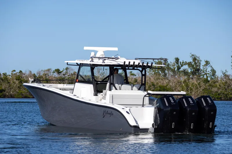 Slide: The Image of 2023 Yellowfin 42 boat with triple outboard engines on calm water. - 6