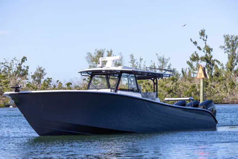 Slide: The Image of 2023 Yellowfin 42 boat cruising on a calm waterway with trees in the background. - 9