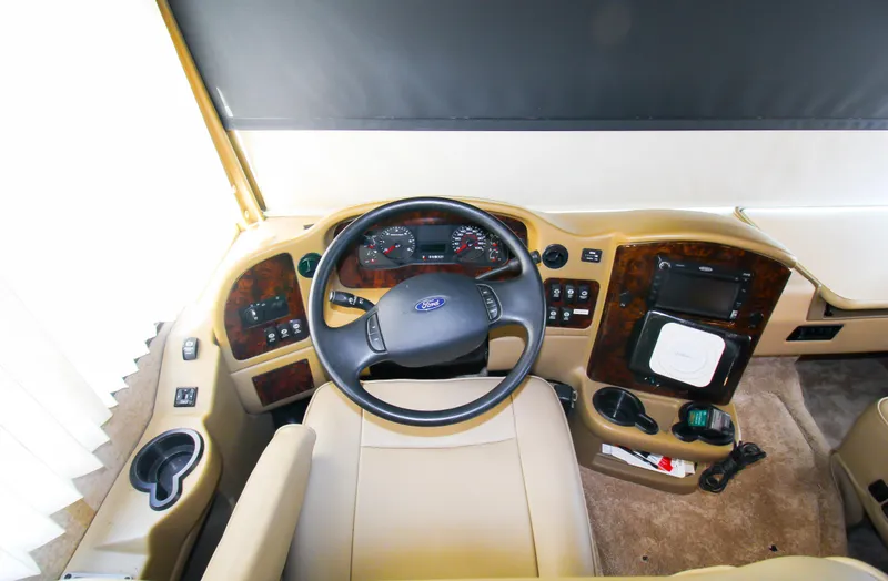 Slide: The Image of 2012 Thor 37DT RV driver's cockpit with steering wheel and dashboard controls. - 16
