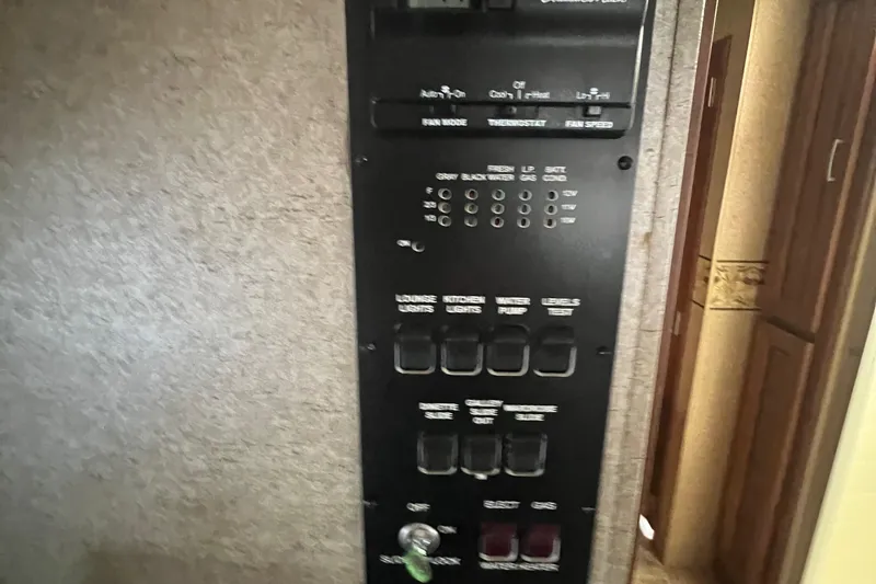 Slide: The Image of Control panel inside a 2012 Thor 37DT RV, showing various switches and indicators. - 29