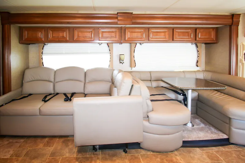 Slide: The Image of Luxurious interior of 2012 Thor 37DT RV with leather seating and dining area. - 4