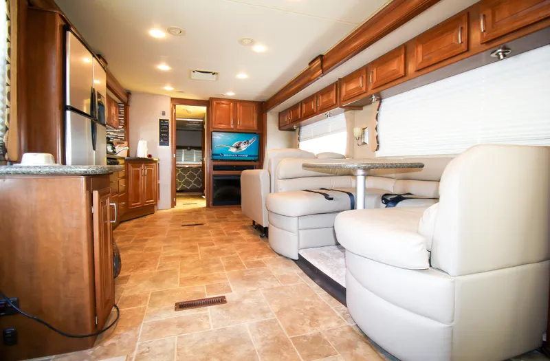 Slide: The Image of 2012 Thor 37DT RV interior with modern kitchen, dining area, and entertainment system. - 5