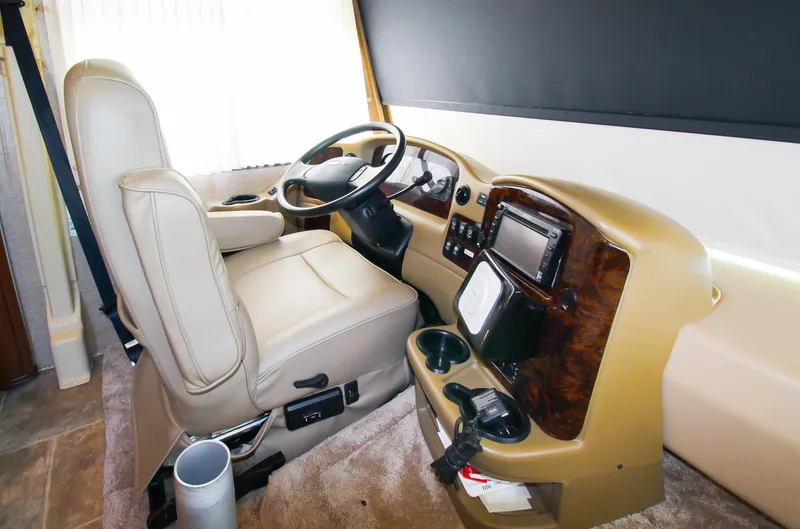 Slide: The Image of 2012 Thor 37DT RV driver's cockpit with beige leather seat and modern dashboard. - 7