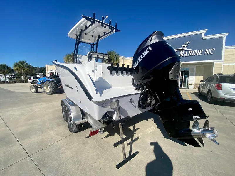 Slide: The Image of 2024 Cape Horn 22OS boat with Suzuki outboard motor at a marine dealership. - 4