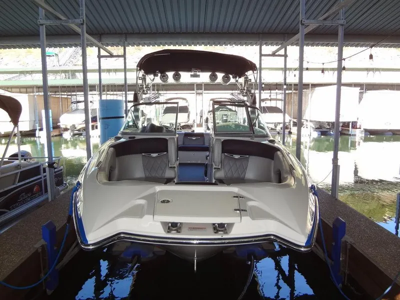 Slide: The Image of 2013 MasterCraft X55 boat on trailer, blue and white design, parked outdoors. - 2