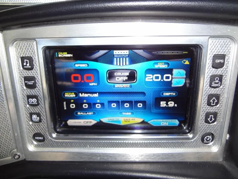 Slide: The Image of 2013 MasterCraft X55 boat dashboard with touchscreen display and control knobs. - 37