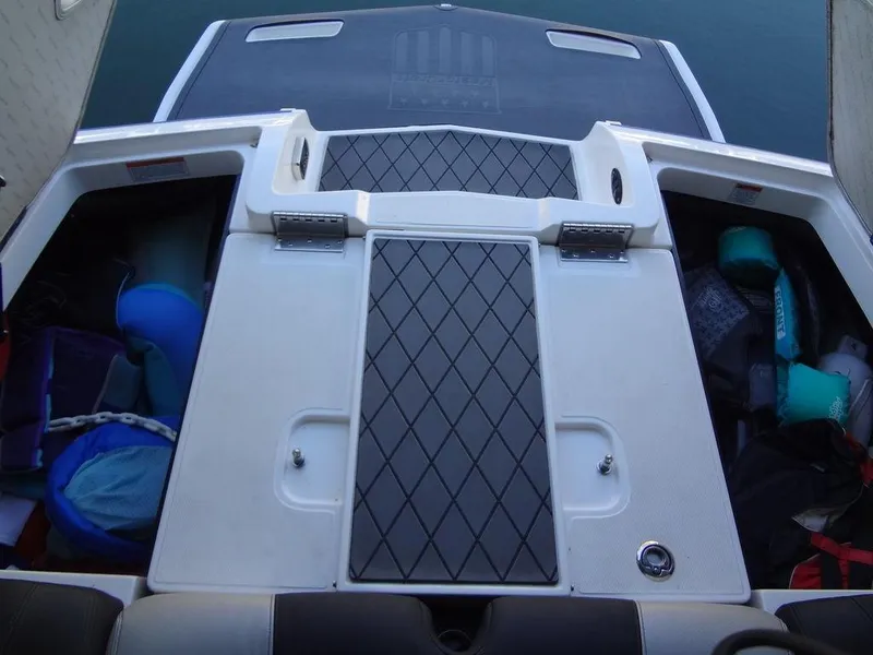 Slide: The Image of 2013 MasterCraft X55 boat engine compartment with black hoses and wiring. - 46