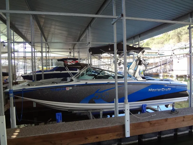 Slide: The Image of 2013 MasterCraft X55 boat docked in a covered marina. - 5