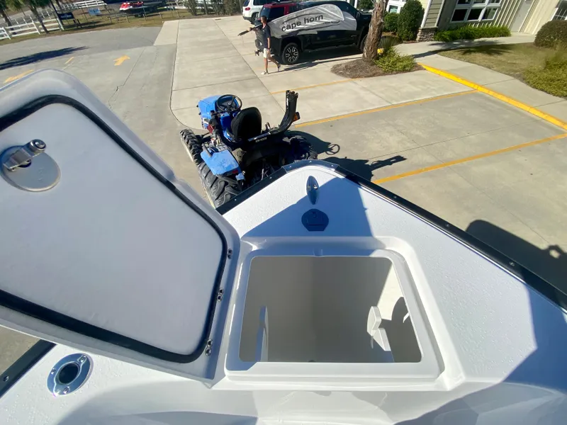 Slide: The Image of 2024 Cape Horn 22OS boat with open storage compartment in a parking lot. - 25