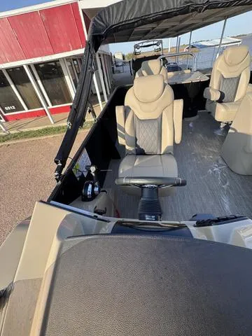 Slide: The Image of 2023 Starcraft CX23FD boat interior with beige seating and steering console. - 14