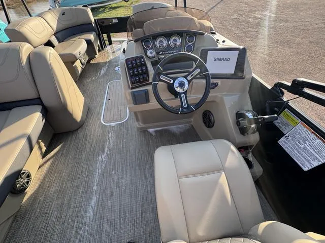 Slide: The Image of 2023 Starcraft CX23FD boat interior with steering wheel and beige seating. - 16