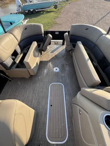 Slide: The Image of 2023 Starcraft CX23FD boat interior with beige seating and spacious deck layout. - 20