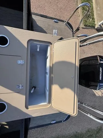 Slide: The Image of 2023 Starcraft CX23FD boat with open storage compartment and Mercury engine. - 7