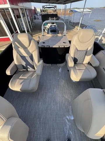 Slide: The Image of 2023 Starcraft CX23FD boat interior with beige seating and lake view. - 9