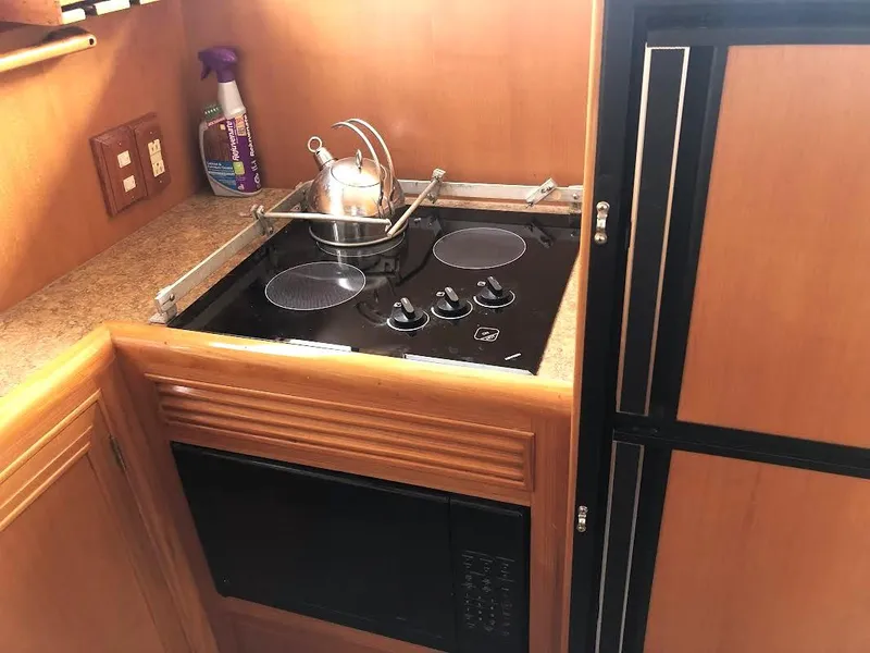 Slide: The Image of Compact kitchen area in a 1999 Ocean Alexander Classico 450 yacht with stove and microwave. - 14
