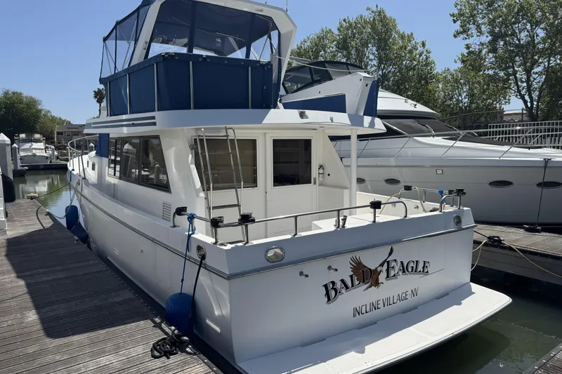 Slide: The Image of 1999 Ocean Alexander Classico 450 yacht docked, featuring "Bald Eagle" name on the stern. - 2