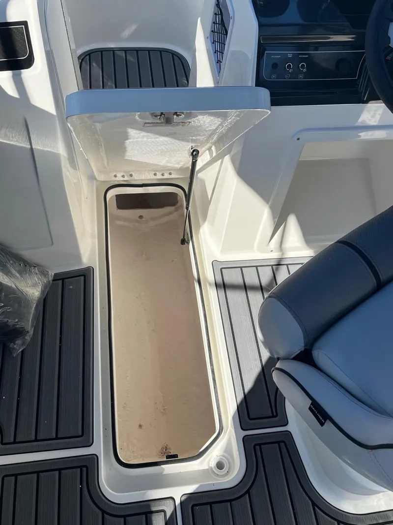Slide: The Image of 2024 Bayliner VR4 boat interior storage compartment with open hatch and seating. - 14