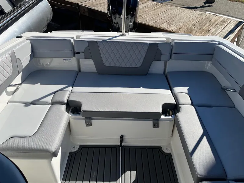 Slide: The Image of 2024 Bayliner VR4 boat with spacious, cushioned seating area and modern design. - 8