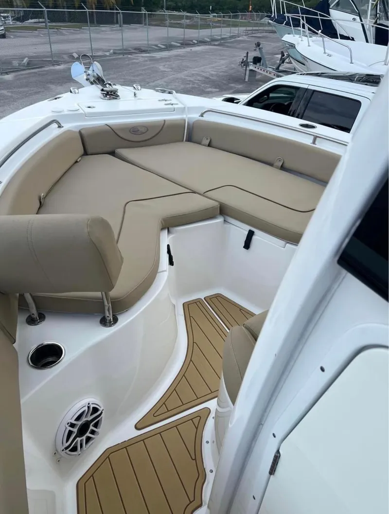 Slide: The Image of 2018 Sea Hunt 235 boat with tan cushioned seating and teak flooring. - 14