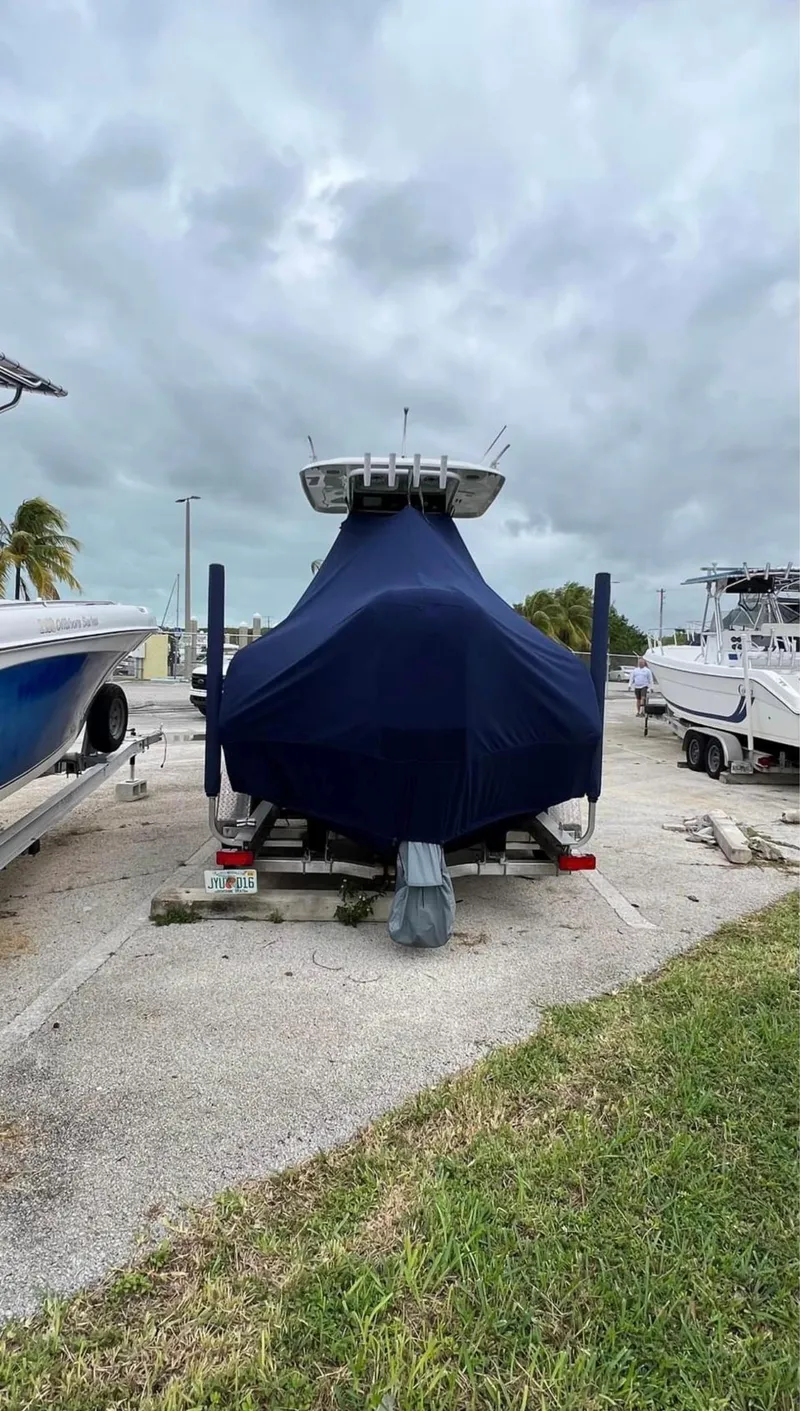 Slide: The Image of 2018 Sea Hunt 235 boat covered and parked on a trailer in a marina. - 15