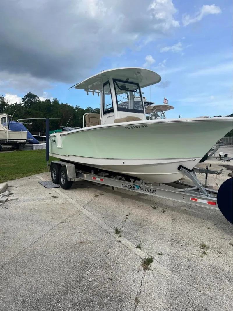 Slide: The Image of 2018 Sea Hunt 235 boat on a trailer in a marina. - 2