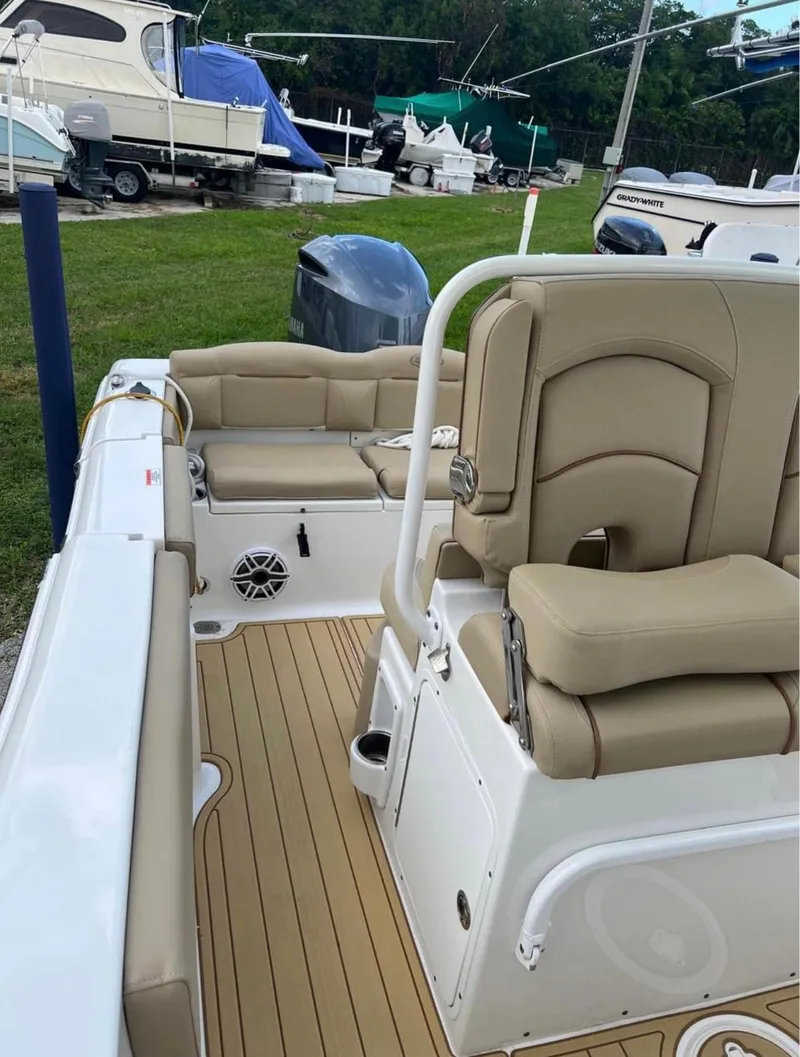 Slide: The Image of 2018 Sea Hunt 235 boat interior with beige seating and teak flooring. - 9