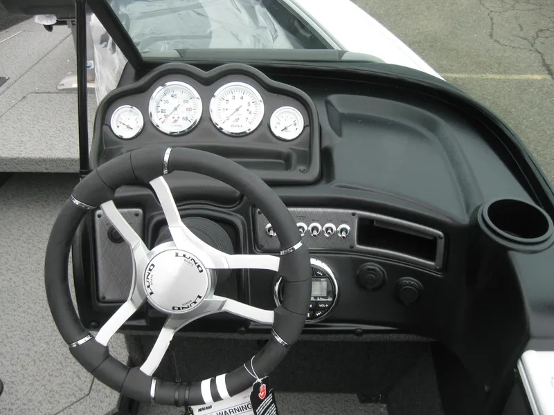 Slide: The Image of 2024 Lund 1775 Crossover XS boat cockpit with steering wheel and dashboard. - 12