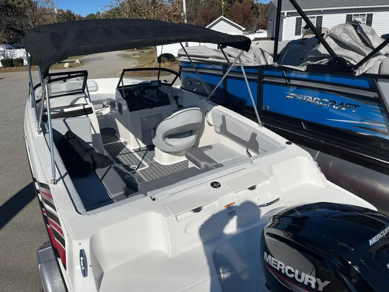 Slide: The Image of 2024 Bayliner VR4 boat with Mercury engine, black canopy, and spacious seating. - 4