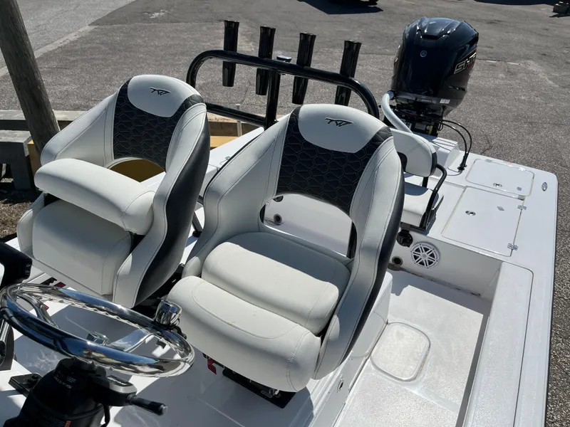 Slide: The Image of 2025 Tidewater 25 TPC boat interior with dual captain's chairs and outboard motor. - 16