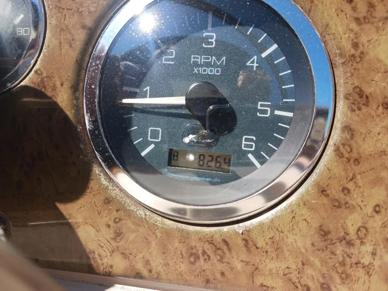 Slide: The Image of Tachometer of 2001 Sea Ray Sundancer showing 8254 RPM on wooden dashboard. - 5