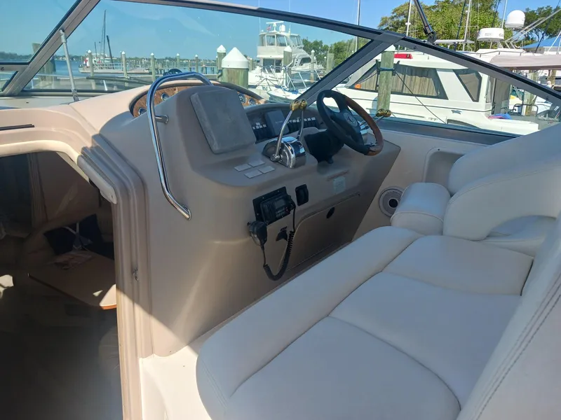 Slide: The Image of 2001 Sea Ray Sundancer boat interior with steering wheel and seating, docked at marina. - 7