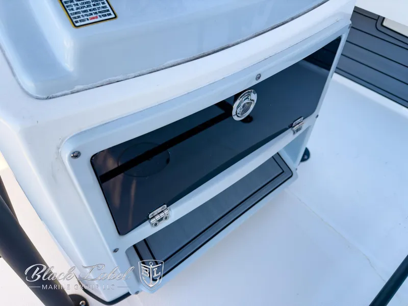 Slide: The Image of 2024 Pathfinder TRS 2200 boat storage compartment with sleek black panel and secure latch. - 17