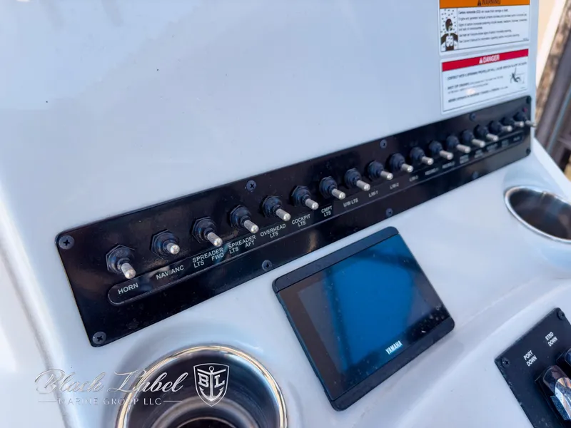 Slide: The Image of Control panel of 2024 Pathfinder TRS 2200 boat with switches and display screen. - 19