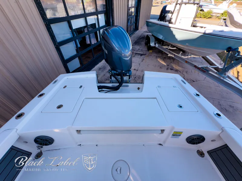 Slide: The Image of 2024 Pathfinder TRS 2200 boat with outboard motor, docked near a building. - 22