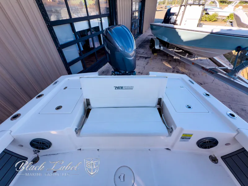 Slide: The Image of 2024 Pathfinder TRS 2200 boat with outboard motor, docked near a building. - 23