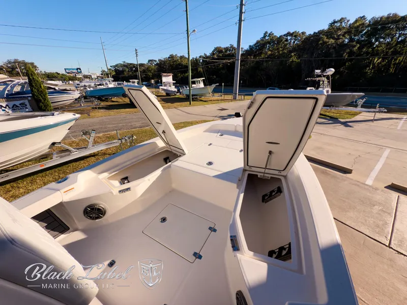 Slide: The Image of 2024 Pathfinder TRS 2200 boat interior with open storage compartments at a marina. - 7