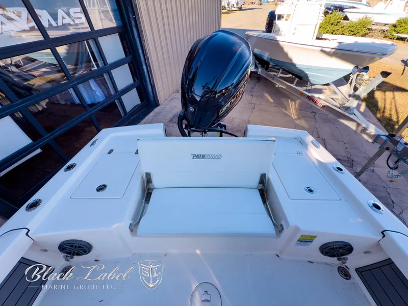 Slide: The Image of 2024 Pathfinder TRS 2200 boat with outboard motor, docked near a building. - 29