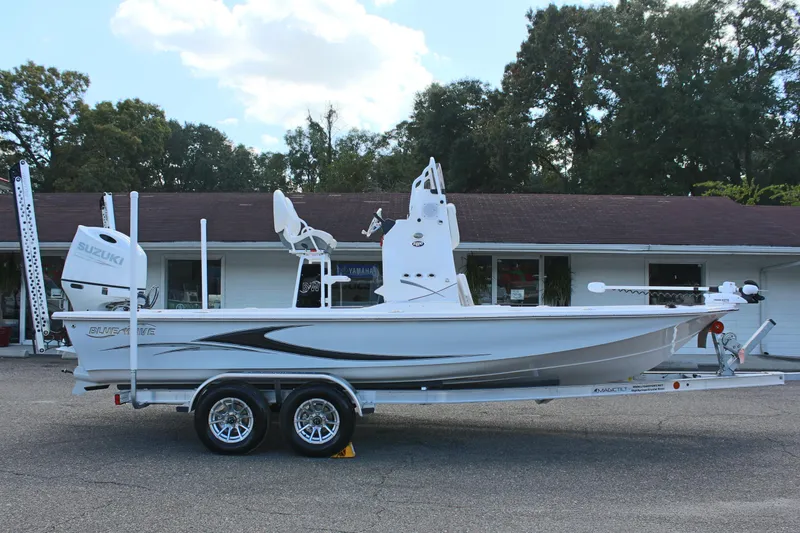 Slide: The Image of 2024 Blue Wave 2200 STL boat on a trailer, parked outdoors. - 11