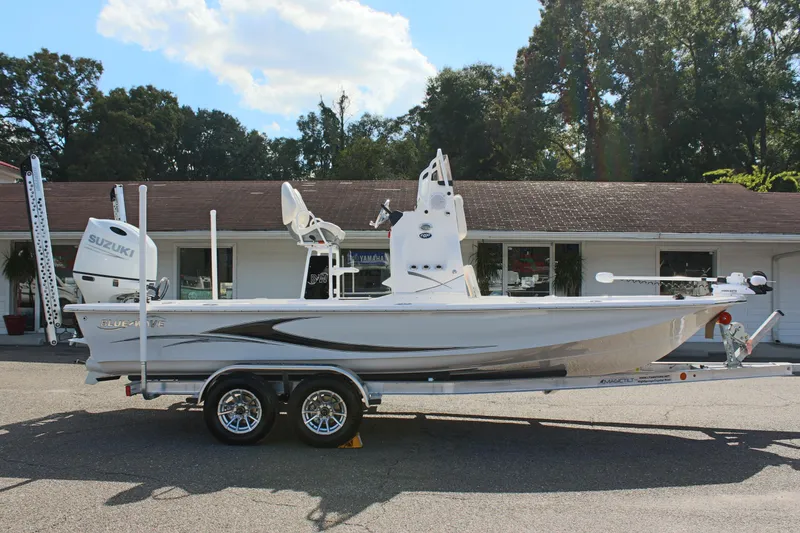Slide: The Image of 2024 Blue Wave 2200 STL boat on a trailer, side view, outdoors. - 13