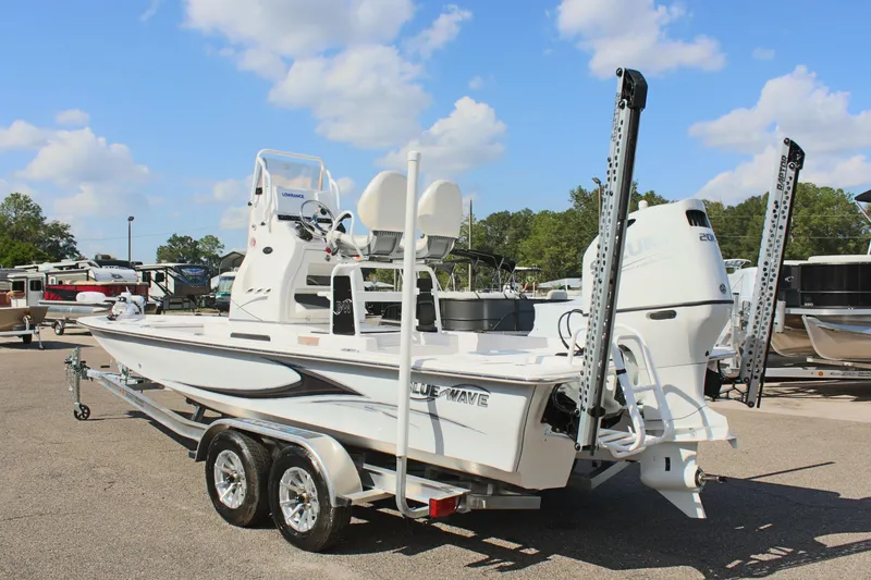 Slide: The Image of 2024 Blue Wave 2200 STL boat on a trailer in a marina. - 18