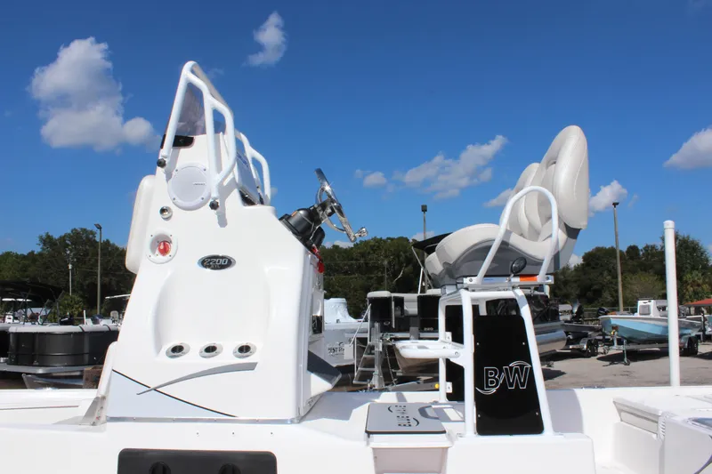 Slide: The Image of 2024 Blue Wave 2200 STL boat with white console and seating under a clear blue sky. - 21