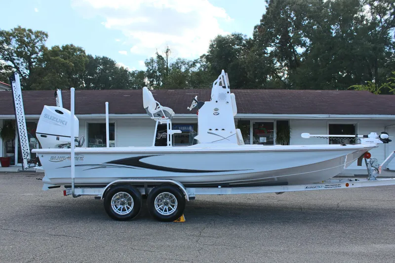 Slide: The Image of 2024 Blue Wave 2200 STL boat on a trailer, parked outdoors. - 9