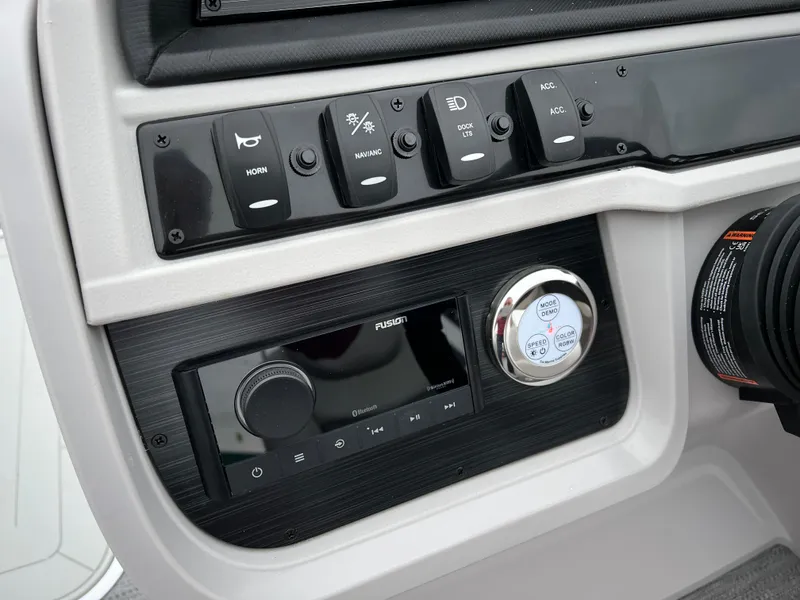 Slide: The Image of Control panel of the 2024 Godfrey SWEETWATER 2286 SB boat with various switches and a Fusion stereo system. - 19