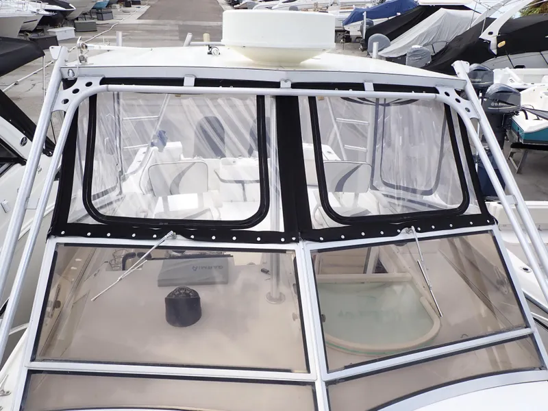 Slide: The Image of 1989 Blackfin 29 Combi boat with clear windshield and white interior, docked at marina. - 15