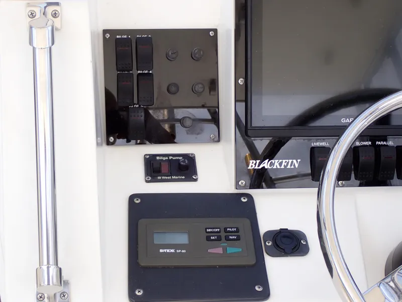 Slide: The Image of 1989 Blackfin 29 Combi boat control panel with switches and display. - 18