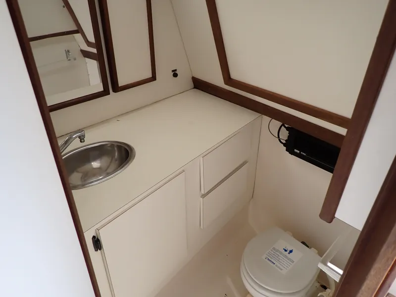 Slide: The Image of 1989 Blackfin 29 Combi boat bathroom with sink, mirror, and toilet. - 9